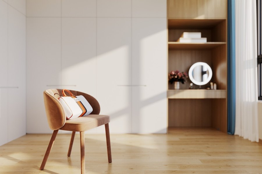 Sala luminosa con una silla tapizada, repisas de madera y un espejo con luz
